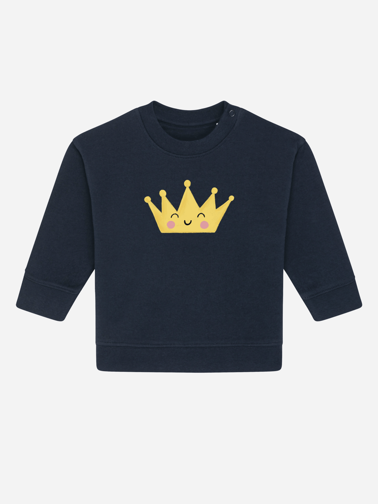 Personalisierbarer Bio-Pullover für Babys mit einer gelben Krone-Applikation auf dunklem Hintergrund.