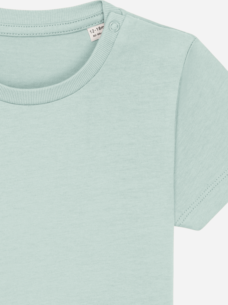 A close-up view of a mint green baby T-shirt, showcasing the soft fabric and shoulder snaps.