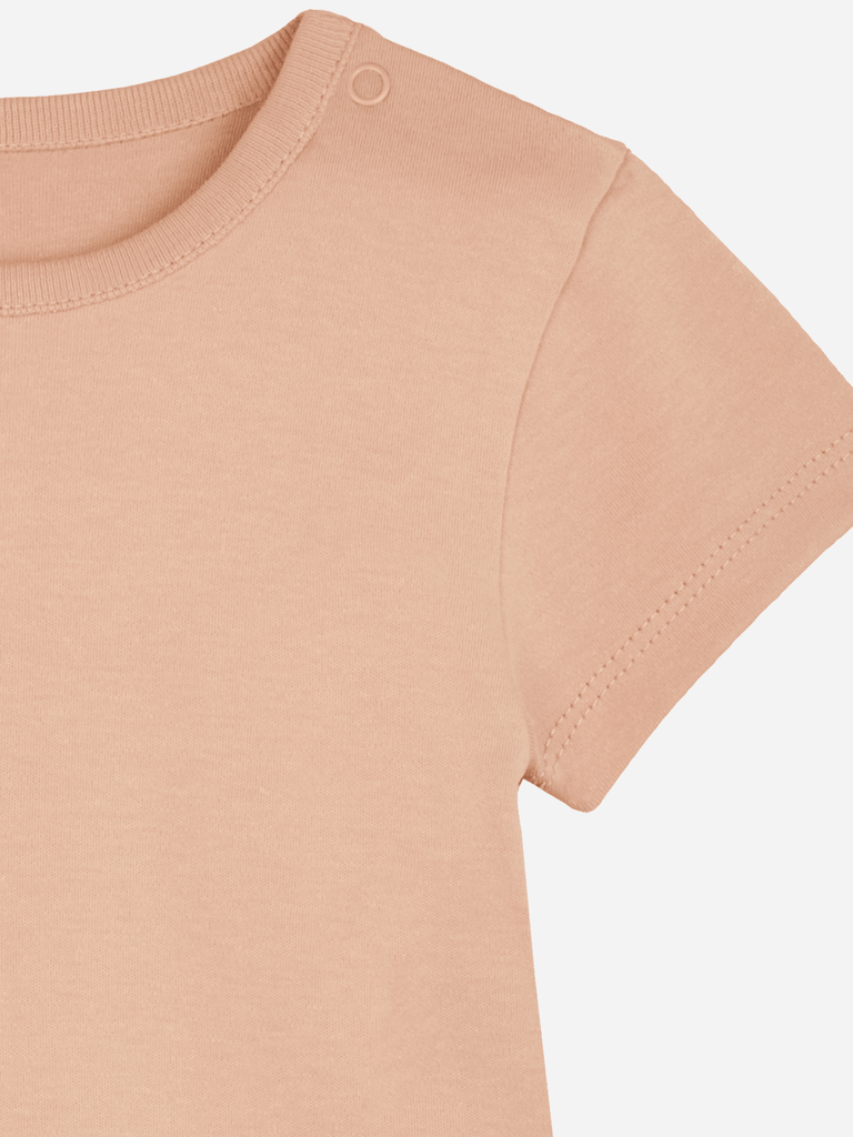 Detailansicht eines peachfarbenen Baby-Bodys mit Druckknöpfen am Halsauschnitt.